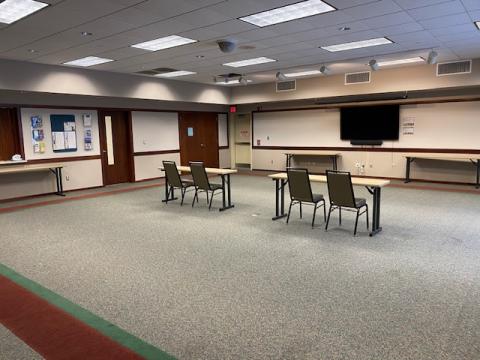 meeting room with two tables and two chairs at each table facing the front of the room