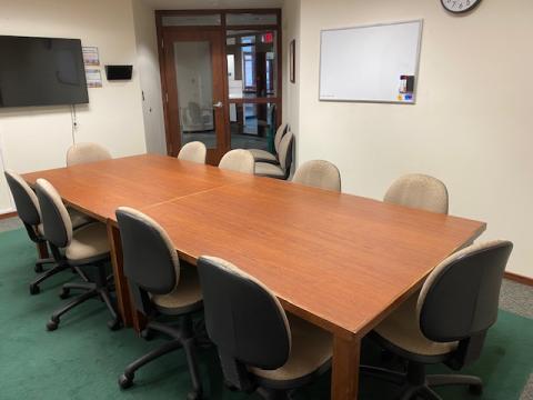 larger board room table with 10 chairs around the table